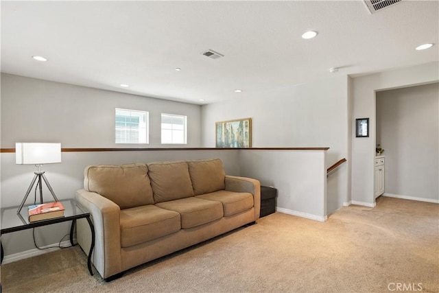living room with recessed lighting, visible vents, and light colored carpet