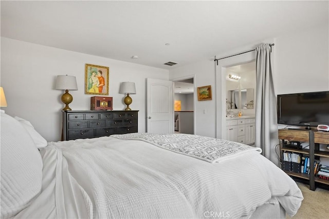 bedroom with carpet floors, ensuite bath, and visible vents