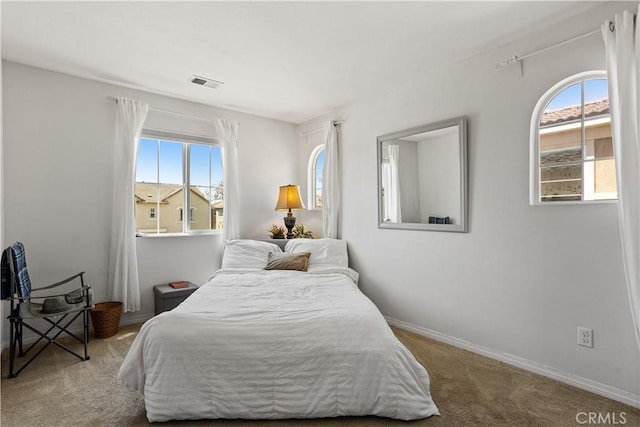 carpeted bedroom featuring baseboards and visible vents