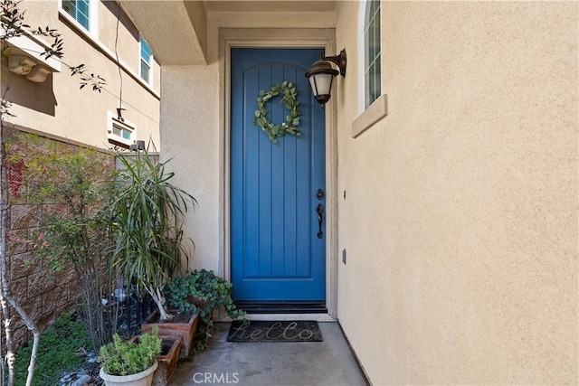 entrance to property featuring stucco siding