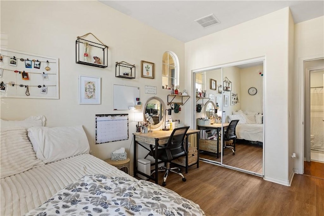 bedroom with dark wood finished floors, baseboards, and visible vents