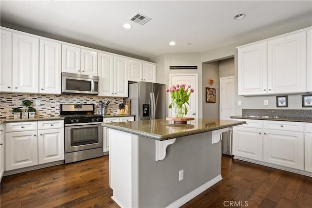 kitchen featuring white cabinetry, dark wood-type flooring, stainless steel appliances, and visible vents