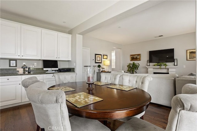 dining area with dark wood-type flooring and visible vents