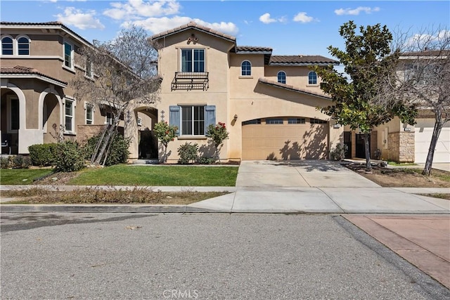 mediterranean / spanish house with a tiled roof, concrete driveway, an attached garage, a front yard, and stucco siding