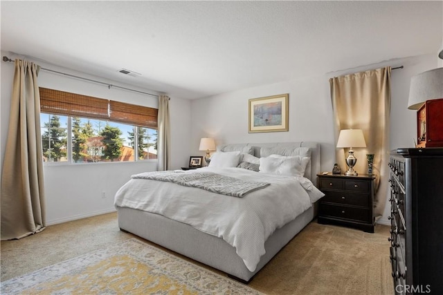 bedroom featuring light carpet, visible vents, and baseboards