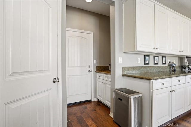 kitchen with dark wood-style floors, white cabinetry, and refrigerator