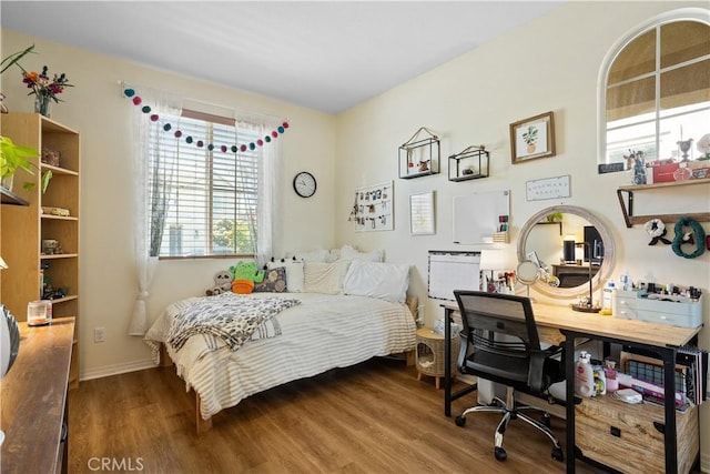bedroom featuring wood finished floors and baseboards