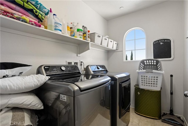 laundry area with independent washer and dryer, light tile patterned floors, and laundry area
