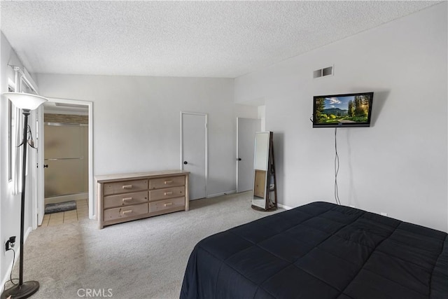 bedroom featuring a walk in closet, visible vents, a textured ceiling, and carpet flooring