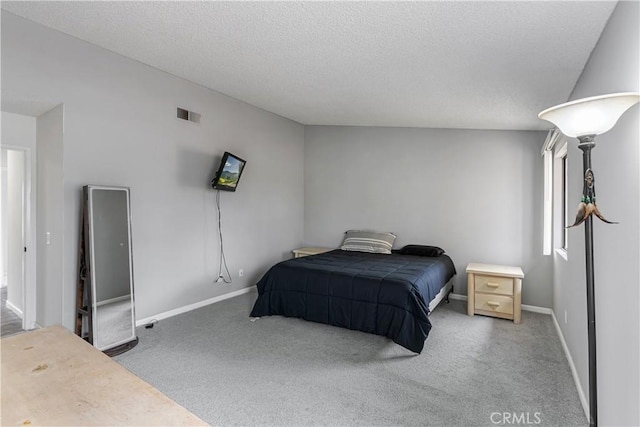 bedroom with baseboards, visible vents, carpet, and a textured ceiling
