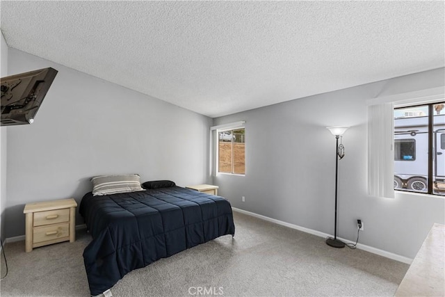 carpeted bedroom featuring baseboards and a textured ceiling