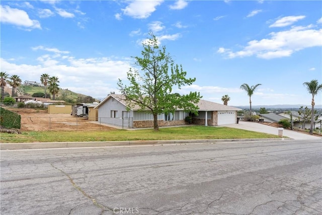 ranch-style home featuring fence private yard, an attached garage, a front lawn, and concrete driveway