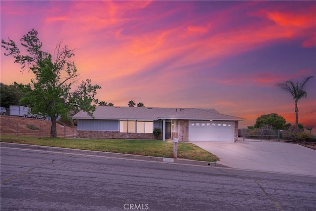 ranch-style home with fence, an attached garage, a front yard, and concrete driveway