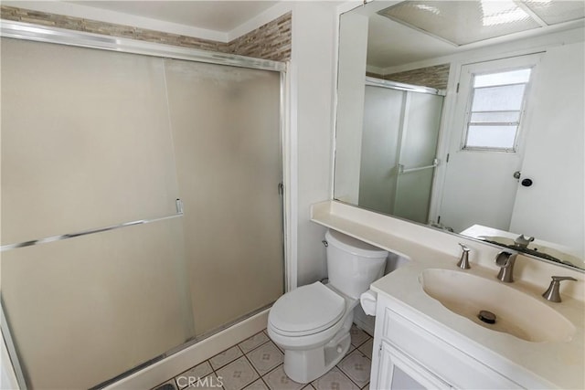 bathroom featuring toilet, baseboards, tile patterned flooring, a shower stall, and vanity