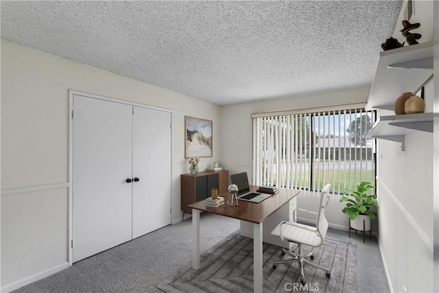 carpeted home office featuring a textured ceiling