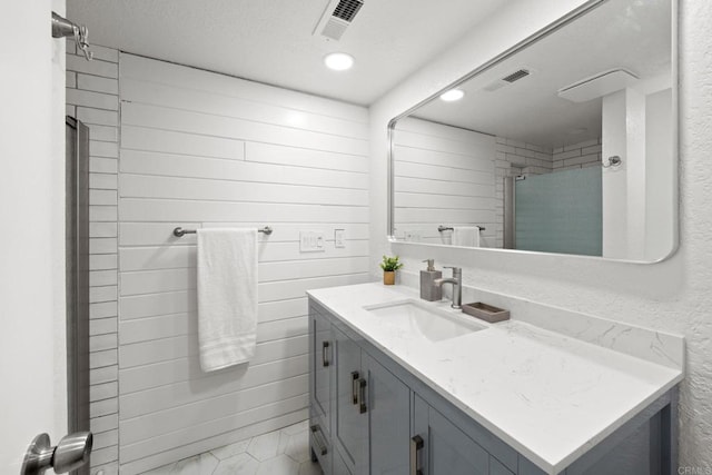 bathroom featuring vanity, visible vents, and a stall shower