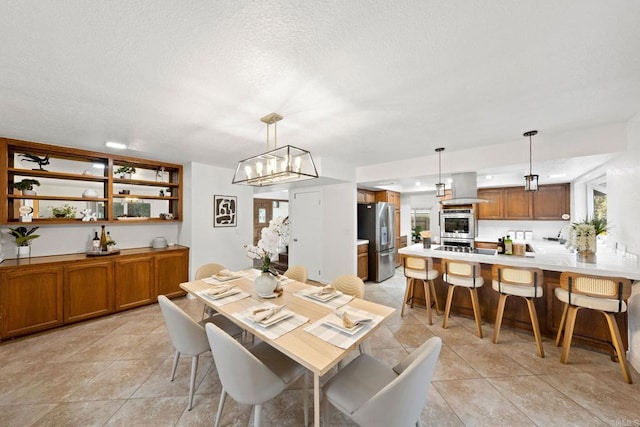 dining area featuring a chandelier, a textured ceiling, and light tile patterned floors