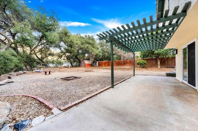 view of patio / terrace featuring a pergola, a fenced backyard, an outdoor structure, and a storage shed