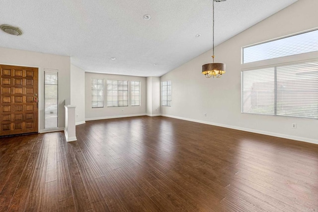 688 Via Encantada, Chula Vista, CA 91913 - unfurnished living room featuring a chandelier, a textured ceiling, dark wood-type flooring, vaulted ceiling, and baseboards