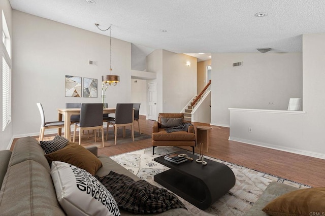 688 Via Encantada, Chula Vista, CA 91913 - living room featuring wood finished floors, a textured ceiling, baseboards, stairs, and a chandelier