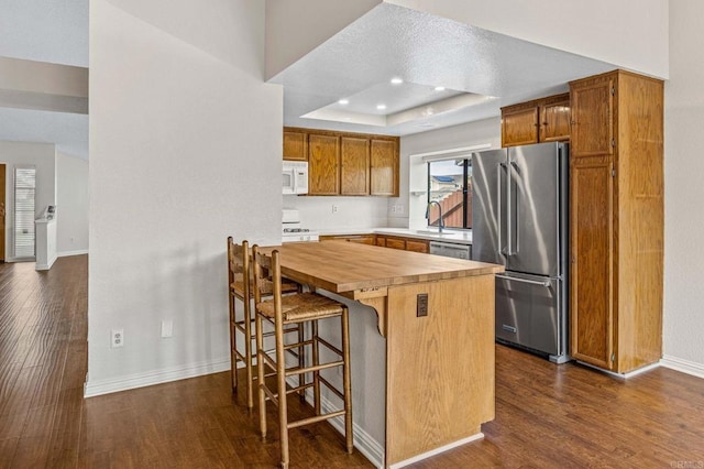 688 Via Encantada, Chula Vista, CA 91913 - kitchen featuring white appliances, wooden counters, dark wood finished floors, baseboards, and a kitchen breakfast bar