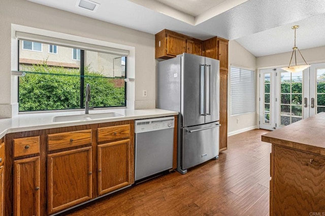 688 Via Encantada, Chula Vista, CA 91913 - kitchen with dishwasher, freestanding refrigerator, a sink, dark wood-style floors, and brown cabinetry