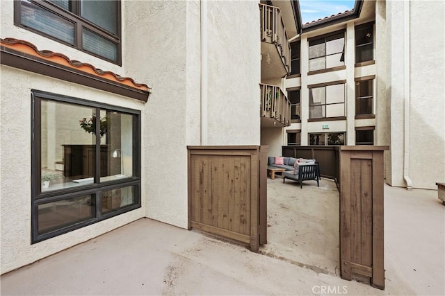 entrance to property with a patio area, a tile roof, and stucco siding