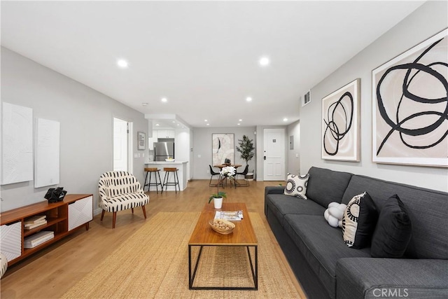 living area featuring light wood-style floors, visible vents, and recessed lighting