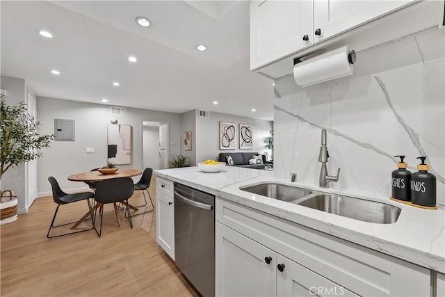 kitchen featuring light wood finished floors, stainless steel dishwasher, a sink, recessed lighting, and white cabinetry