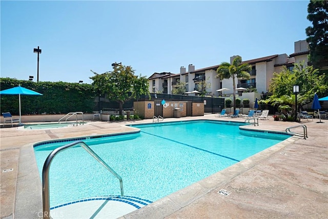 pool with fence, a patio area, and a residential view