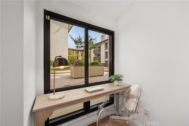 doorway to outside with baseboards and a textured wall