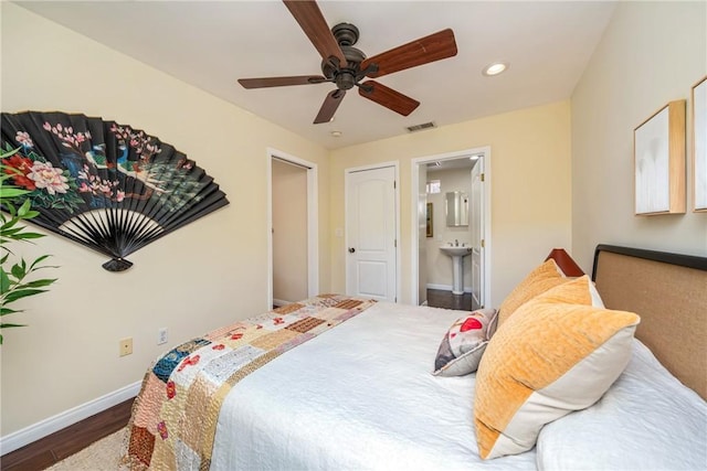 bedroom with wood finished floors, connected bathroom, baseboards, visible vents, and recessed lighting
