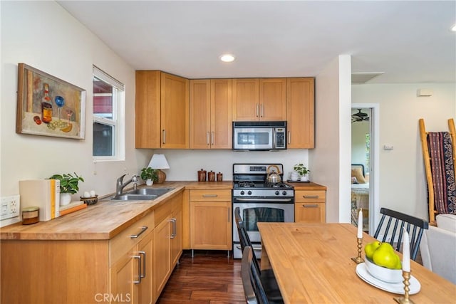 kitchen featuring stainless steel appliances, a sink, dark wood-style flooring, recessed lighting, and wood counters