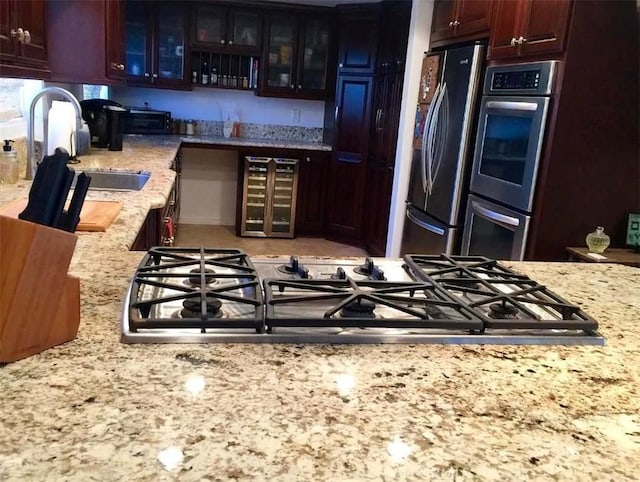 1904 Carnegie Ln Unit 2, Redondo Beach, CA 90278 - kitchen with glass insert cabinets, beverage cooler, light stone counters, a sink, and stainless steel appliances