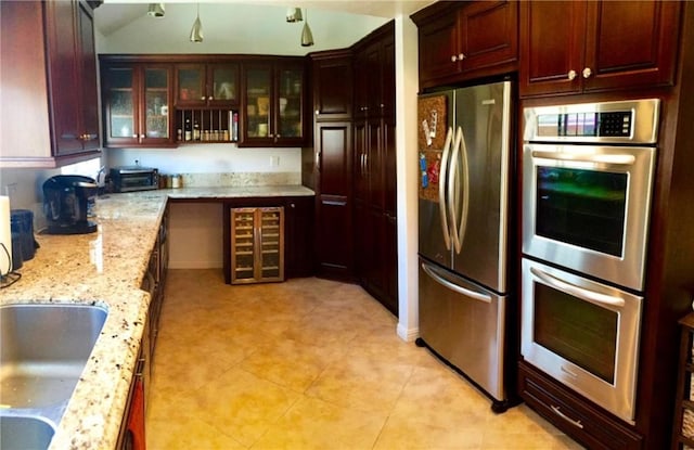 1904 Carnegie Ln Unit 2, Redondo Beach, CA 90278 - kitchen with light stone counters, beverage cooler, stainless steel appliances, light tile patterned floors, and glass insert cabinets