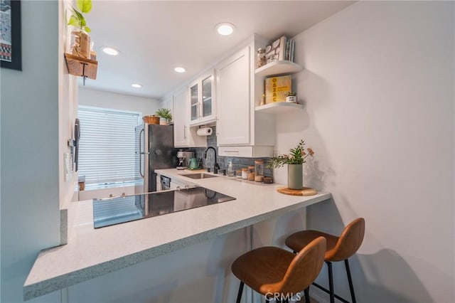 1600 Redondo Ave Unit 4, Long Beach, CA 90804 - kitchen featuring freestanding refrigerator, open shelves, black electric stovetop, a breakfast bar, and white cabinets