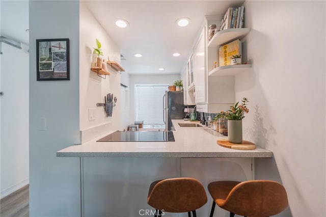 1600 Redondo Ave Unit 4, Long Beach, CA 90804 - kitchen featuring open shelves, black electric cooktop, white cabinetry, a kitchen bar, and a peninsula