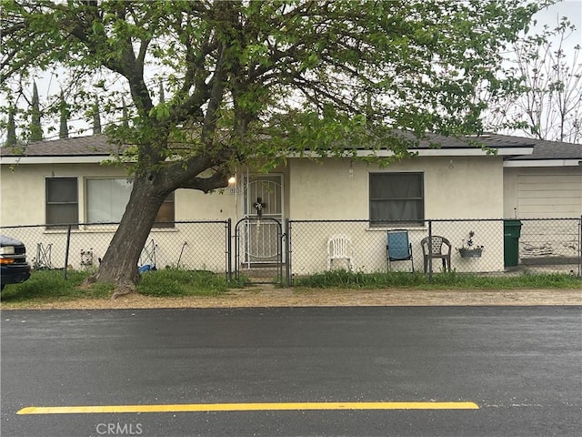 951 E 7th St, Beaumont, CA 92223 - view of front of property featuring a gate, stucco siding, and roof with shingles