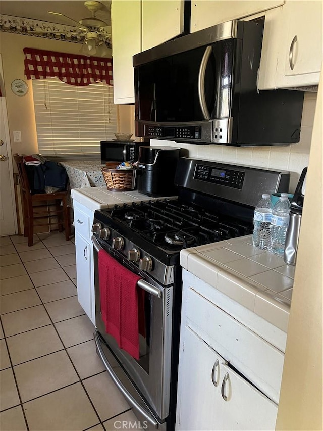 951 E 7th St, Beaumont, CA 92223 - kitchen with tile counters, appliances with stainless steel finishes, light tile patterned floors, and white cabinetry