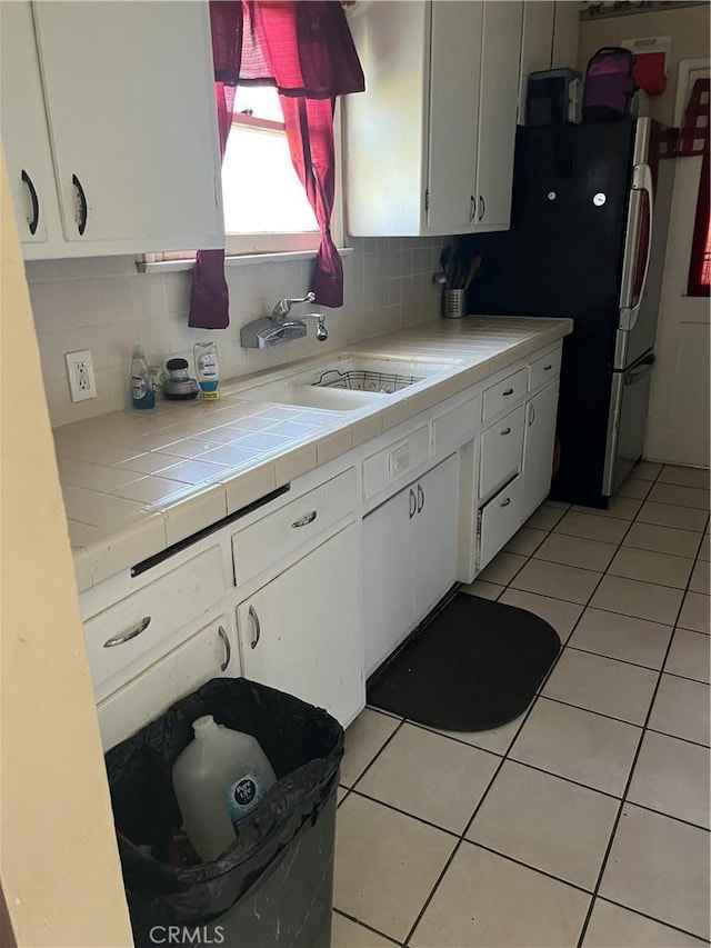 951 E 7th St, Beaumont, CA 92223 - kitchen featuring white cabinets, tasteful backsplash, and light tile patterned floors