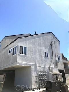rear view of house featuring stucco siding