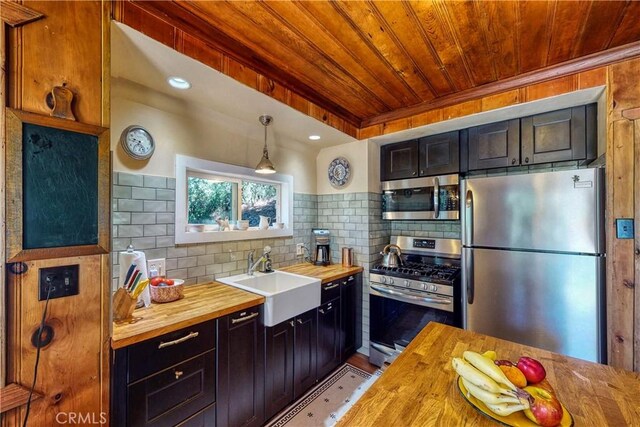 kitchen featuring a sink, wood counters, wood ceiling, backsplash, and appliances with stainless steel finishes