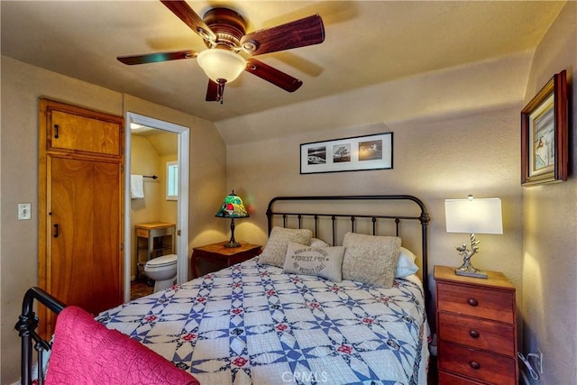 bedroom with ceiling fan, vaulted ceiling, and ensuite bathroom