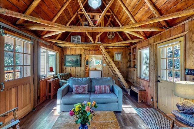 living room featuring wood-type flooring, wood walls, wooden ceiling, and vaulted ceiling with beams