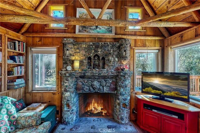 living area with plenty of natural light, wood walls, beam ceiling, and high vaulted ceiling