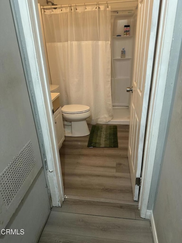 1014 Rialto St, Oxnard, CA 93035 - full bathroom with toilet, vanity, wood finished floors, and a shower with shower curtain
