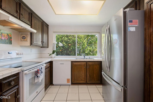 1126 Lawrence Way, Oxnard, CA 93035 - kitchen with white appliances, a sink, under cabinet range hood, tile countertops, and dark brown cabinets