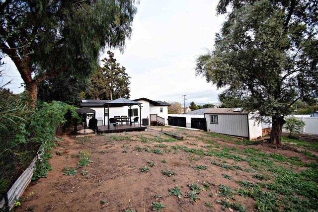 view of yard with fence, an outbuilding, a gazebo, and a detached garage