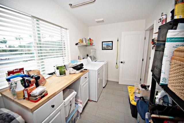 washroom featuring independent washer and dryer and cabinet space