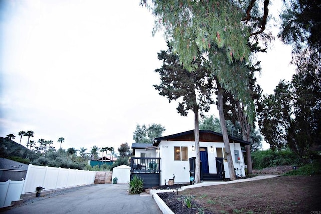 view of front of property with stucco siding, fence, and a deck